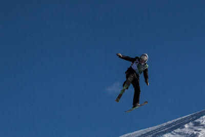 Low angle view of woman jumping in mid-air