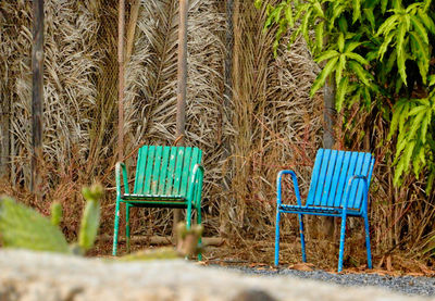 Empty chairs and table on field