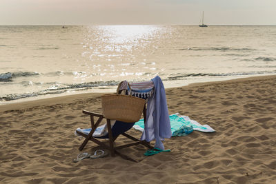 Rear view of chair on shore at beach