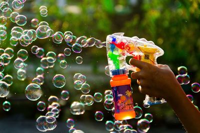 Cropped hand playing with bubble wand