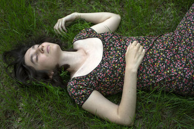 A young woman lying  down on the grass