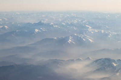 Aerial view of snowcapped mountains against sky