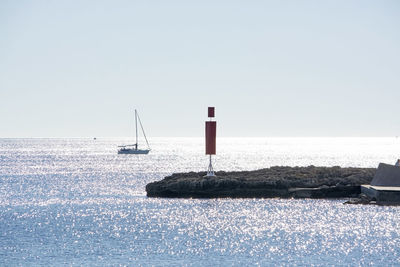 Sailboat on sea against clear sky