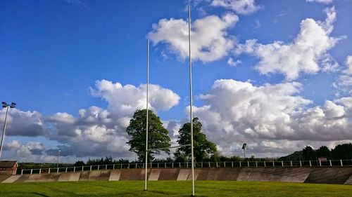 Trees on field against cloudy sky