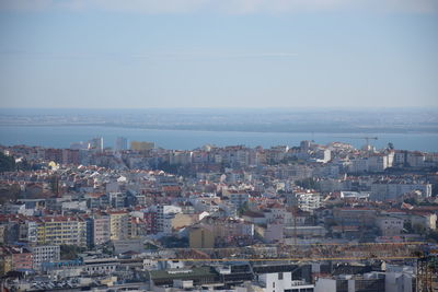 High angle view of townscape by sea against sky