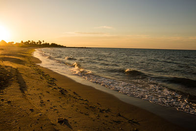 Scenic view of beach against sky during sunset