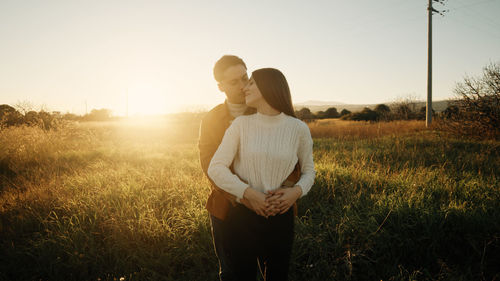 Romantic couple hugging outdoor at sunset light