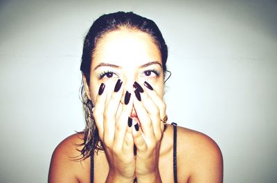 Close-up portrait of young woman against white background