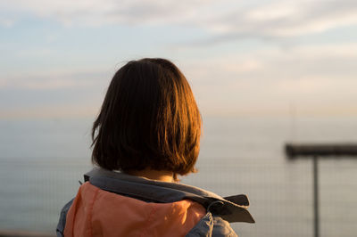 Rear view of woman standing against sky