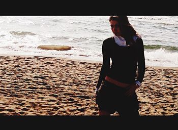 Rear view of woman standing on beach