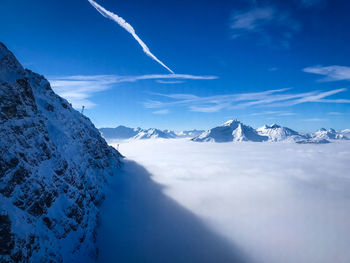 Scenic view of snowcapped mountains against blue sky