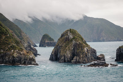 Scenic view of sea and mountains against sky