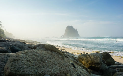 Rocks on beach against sky