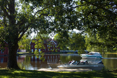 Boats in river against trees