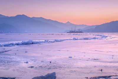 Scenic view of snowcapped mountains against sky during sunset