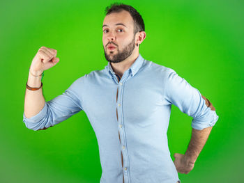 Young man standing against gray background