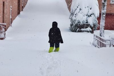 Rear view of person on snow covered field