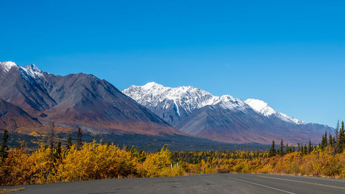 Scenic view of snowcapped mountains against clear blue sky