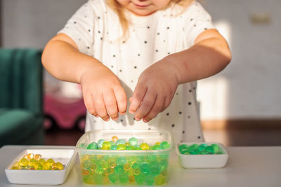 Midsection of girl playing with hydro gel