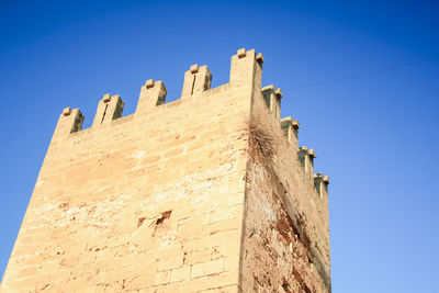 Low angle view of fort against clear blue sky