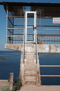 Metallic structure by sea against blue sky