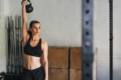 Female athlete exercising with kettlebell in gym