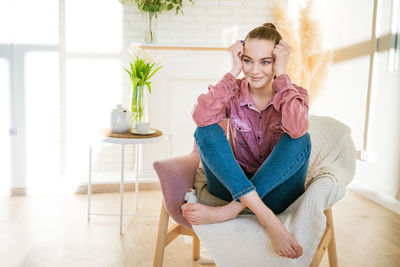 Smiling caucasian millennial girl sitting resting in chair in casual clothes