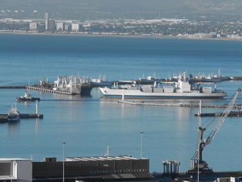 Boats in harbor with city in background