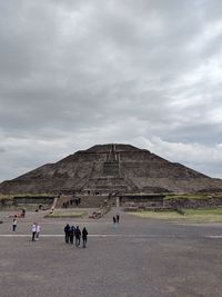 Group of people on mountain against sky
