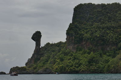 Rock formations by sea against sky