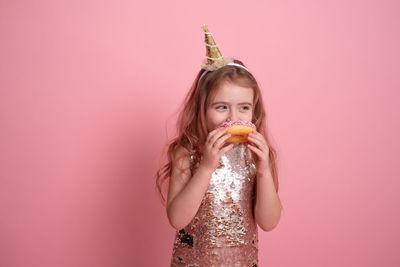 Portrait of young woman drinking juice against yellow background