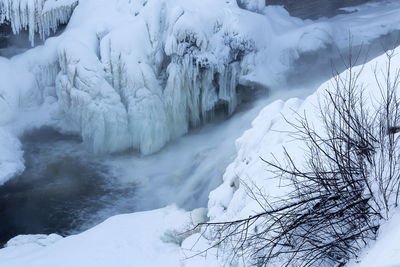 Detail of the snowy banks of the st. charles river with the kabir kouba waterfall and icicles