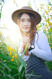 Young woman wearing hat while standing on field