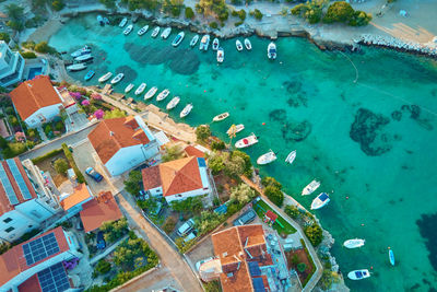Coastal village with red-roofed houses, turquoise waters and boats along shore