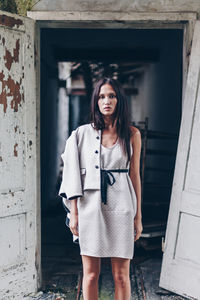 Portrait of woman standing at entrance of building