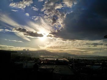 View of cityscape against cloudy sky