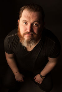 Portrait of man against black background