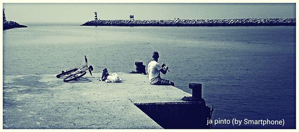 Man on pier in sea