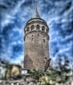 Low angle view of tower against cloudy sky