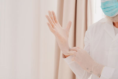 Midsection of woman holding white while standing at home