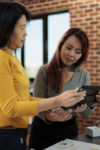 Businesswomen sharing tablet pc at office