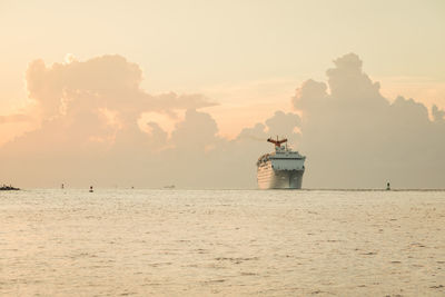 Mid distance of cruise ship on sea against cloudy sky