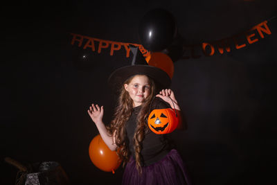 Portrait of woman holding illuminated halloween at night