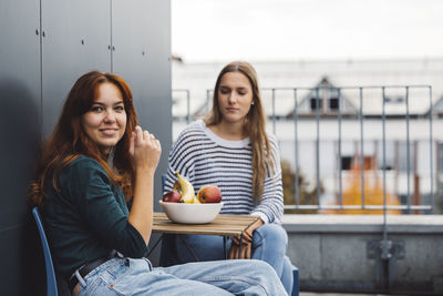 Portrait of smiling friends sitting at home