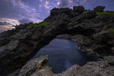 Rock formations by sea against sky