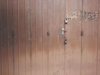 Close-up of padlocks on wooden door