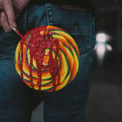 Midsection of man holding lollipop