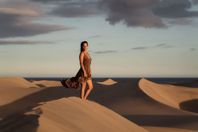 Woman on beach by sea against sky