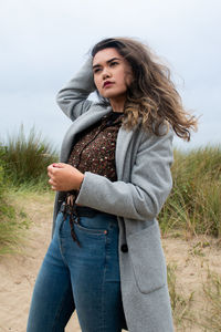 Beautiful young woman standing on beach against sky, lovely cover photo 