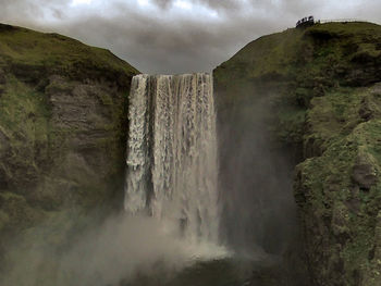 Scenic view of waterfall against sky